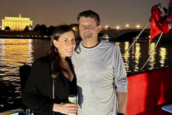 a man and a woman standing in front of water