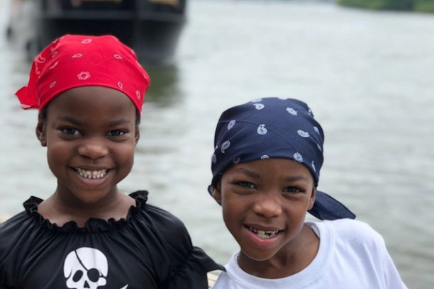 a group of young men standing next to a body of water