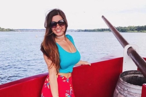 a woman standing in front of a body of water