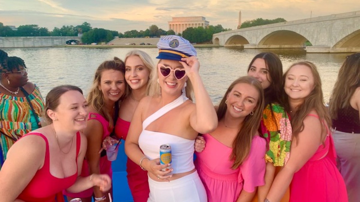a group of people posing in front of a body of water