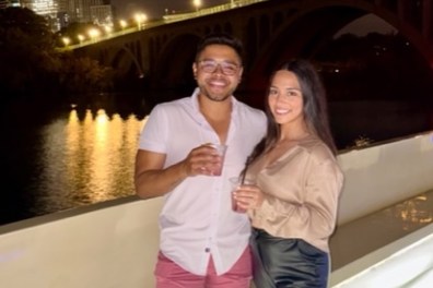 a person standing in front of a bridge posing for the camera