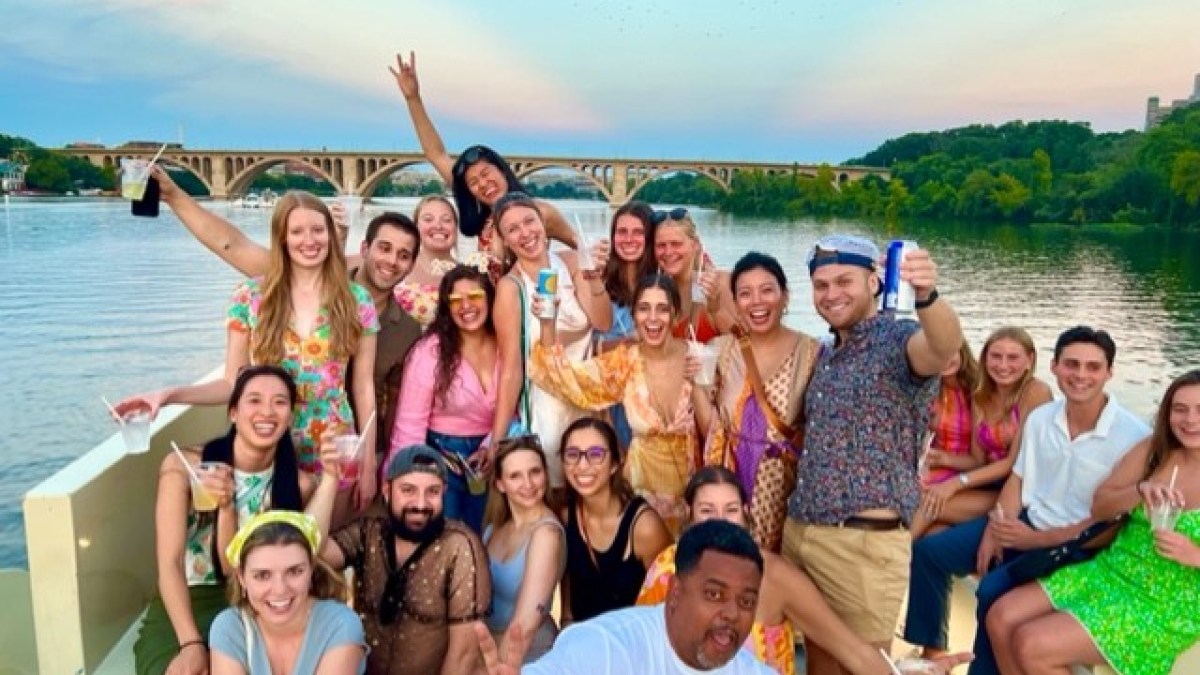 a group of people posing in front of a body of water