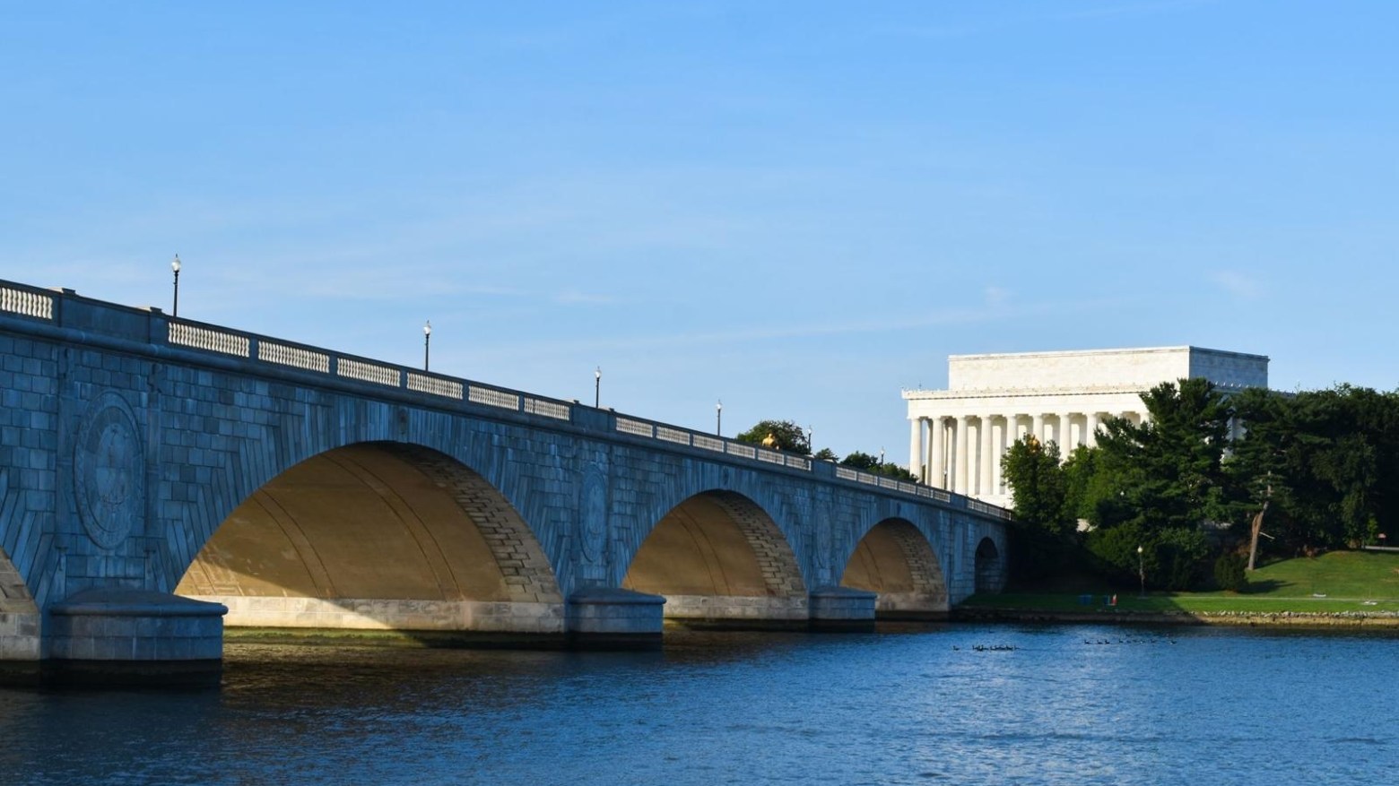 a train crossing a bridge over a body of water