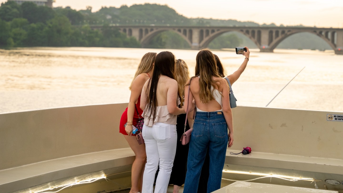 a woman standing in front of a body of water