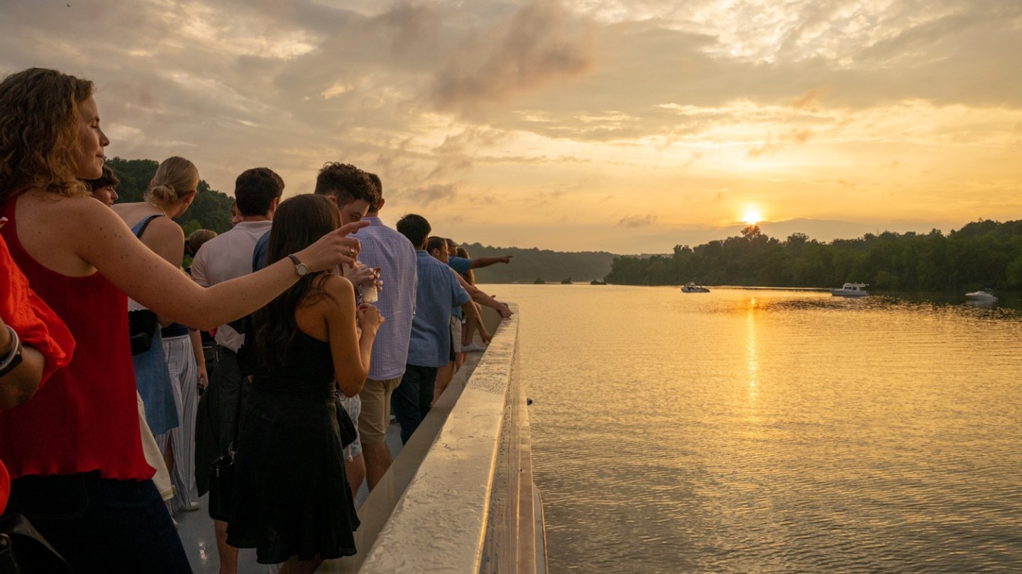 a group of people standing next to a body of water