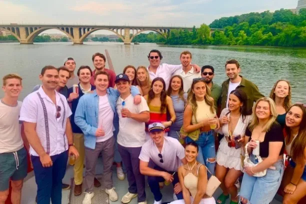 a group of people posing in front of a body of water